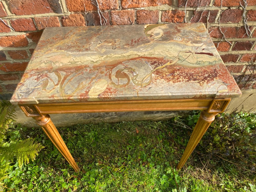 An 18th-century Neoclassical console table with a variegated marble top, carved apron, square corner rosettes, and fluted tapered legs. View VI