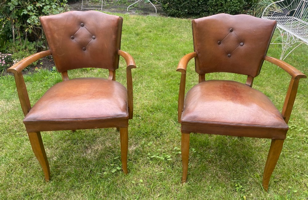 A pair of French Art Deco bridge armchairs with tan brown leather upholstery, diamond button-tufted backrests, and wooden frames. View II