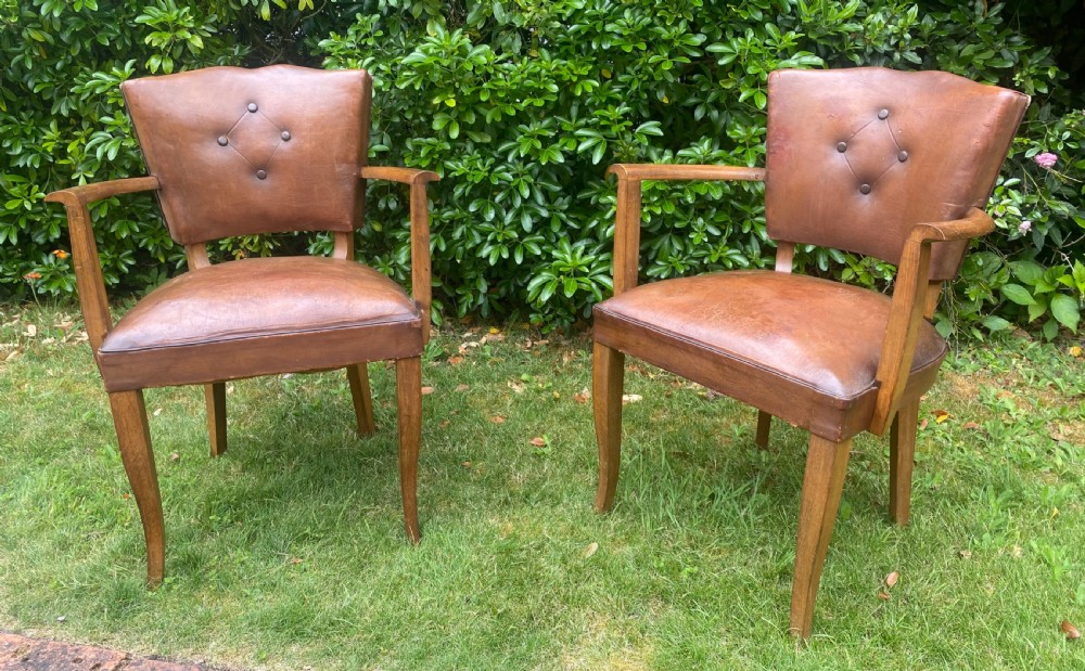 A pair of French Art Deco bridge armchairs with tan brown leather upholstery, diamond button-tufted backrests, and wooden frames. View III