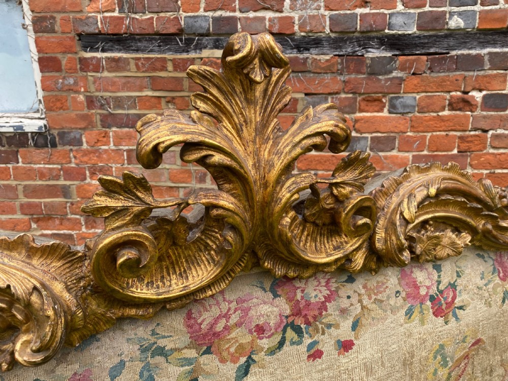 An expansive Venetian style headboard featuring a pictorial woven floral tapestry panel topped with an elaborately carved giltwood cresting. View III