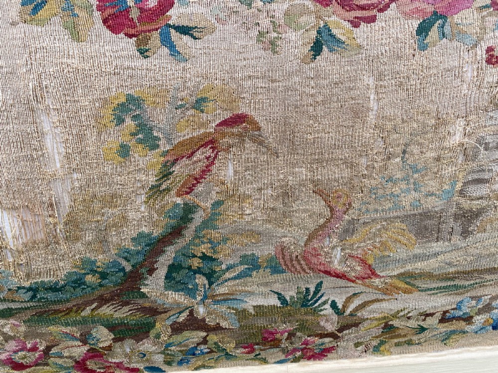 An expansive Venetian style headboard featuring a pictorial woven floral tapestry panel topped with an elaborately carved giltwood cresting. View V