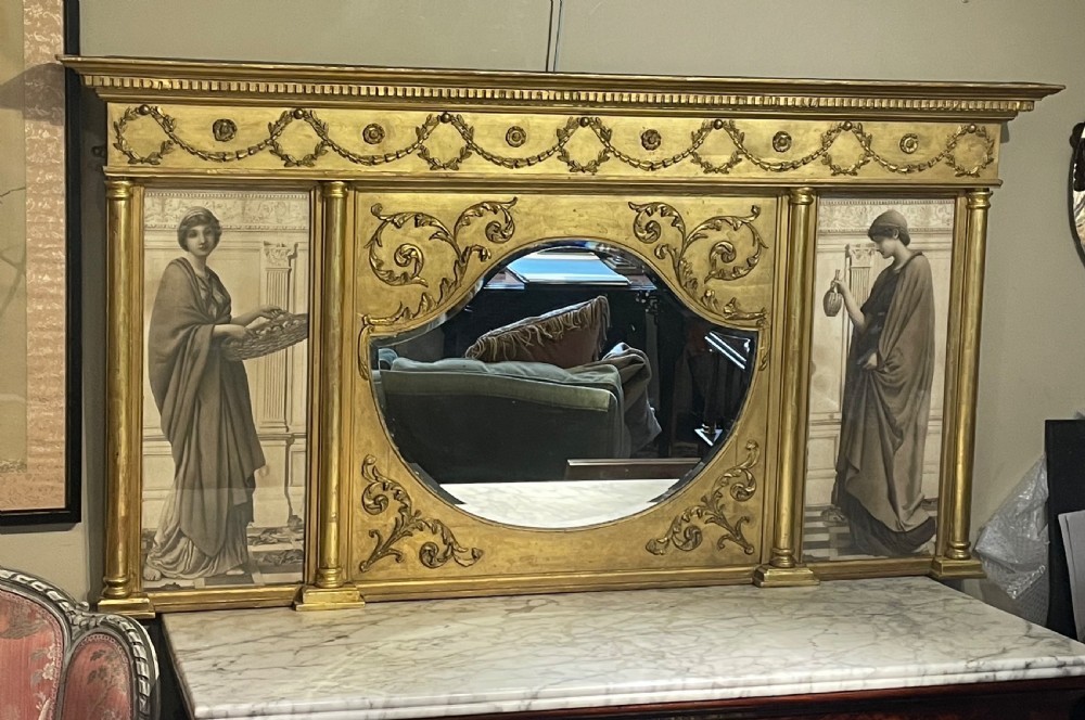 A wide Victorian giltwood overmantel mirror featuring a central shaped mirror plate flanked by classical female figures and decorated with festoon swags. View VII