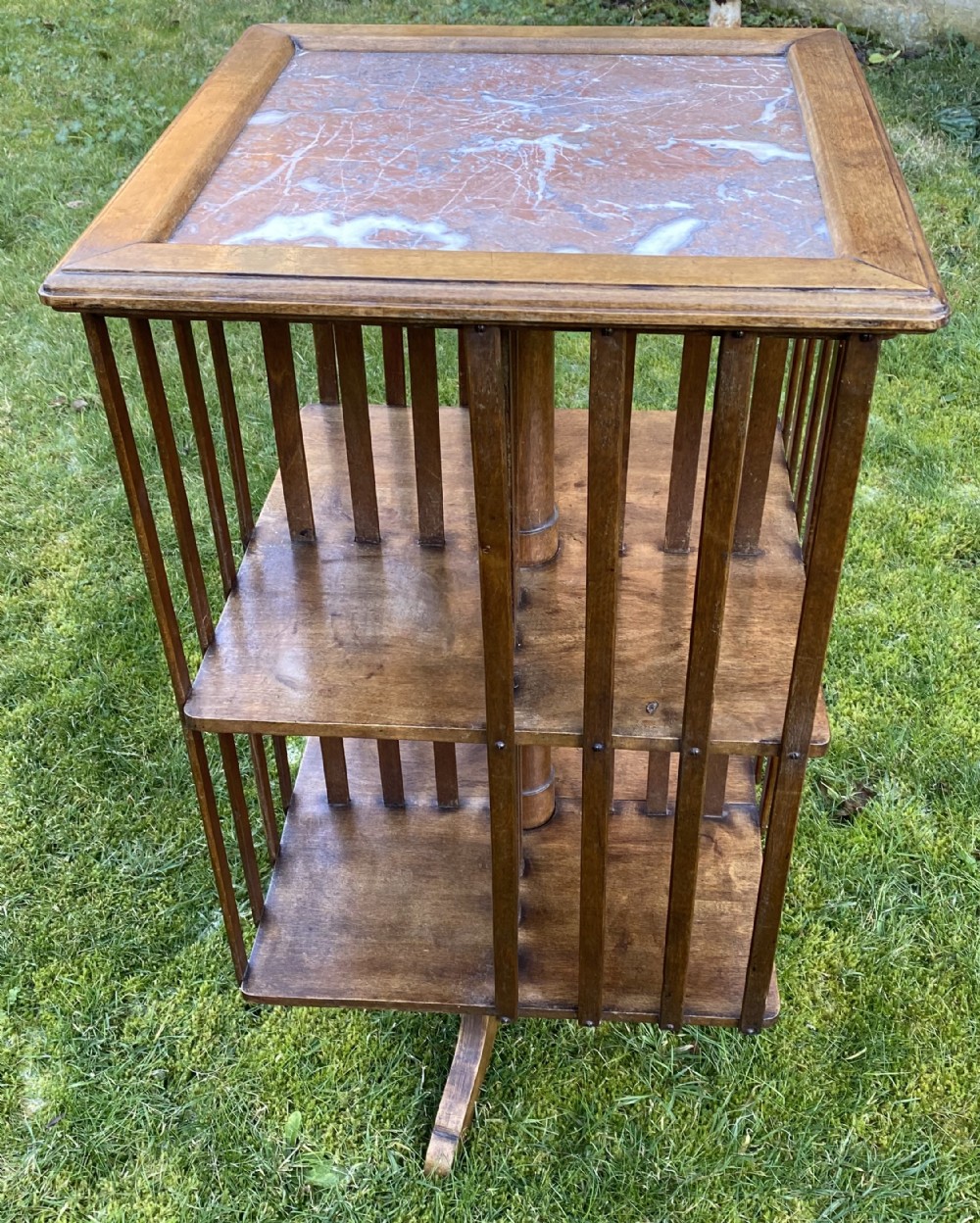 Revolving bookcase in walnut with marble top