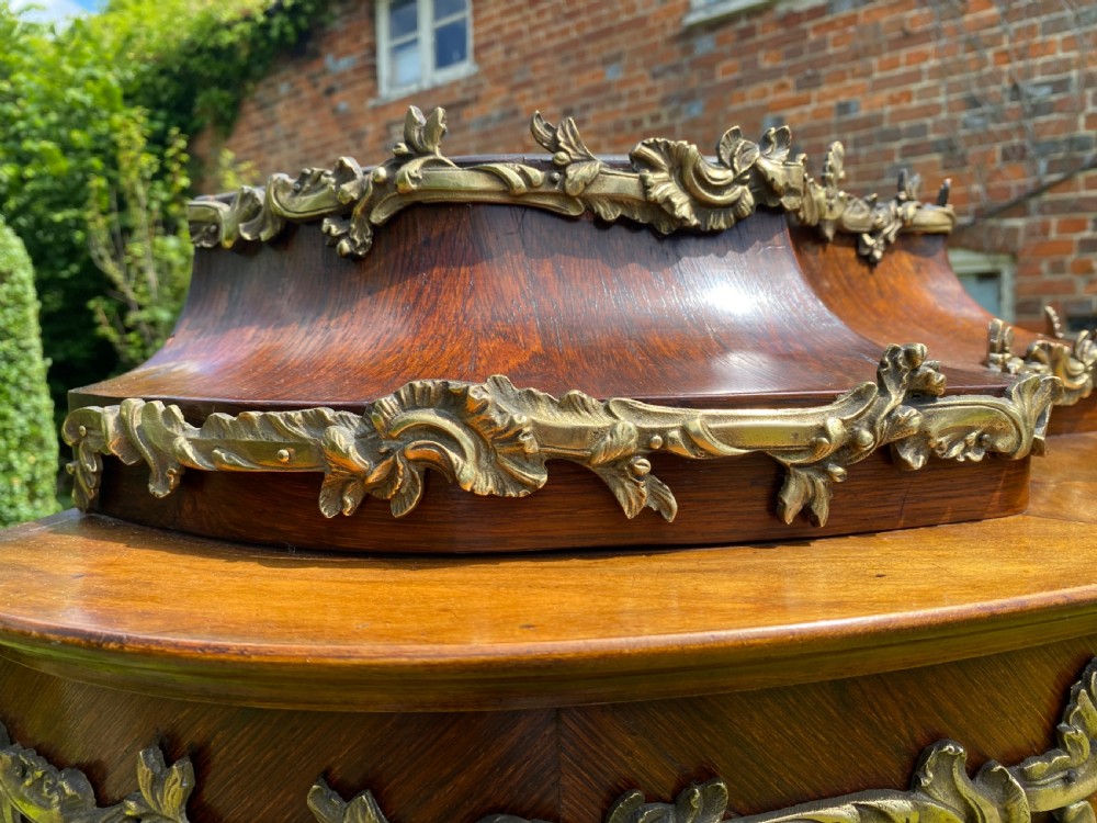 A French Rococo style serpentine glazed vitrine cabinet featuring dark wood veneer, intricate floral marquetry inlay on the lower panel, and decorative gilt bronze ormolu mounts. View IV
