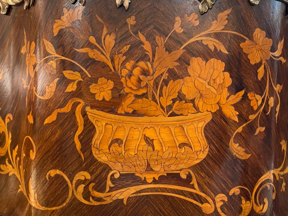 A French Rococo style serpentine glazed vitrine cabinet featuring dark wood veneer, intricate floral marquetry inlay on the lower panel, and decorative gilt bronze ormolu mounts. View VII