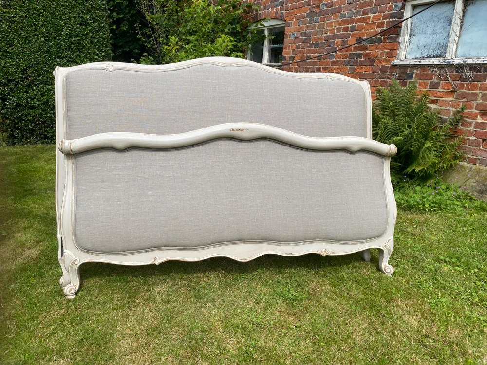A French Louis XV style upholstered kingsize bed frame with a painted grey timber border and neutral linen fabric panels. View II