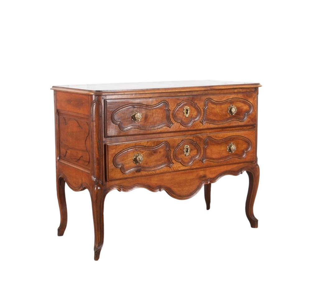A freestanding cherrywood two-drawer commode with shaped apron, cabriole legs, and brass hardware.