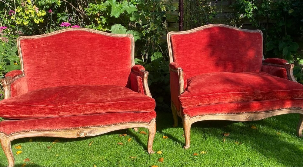 A pair of sofas in old rubbed paint finish with red velvet