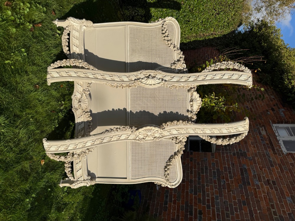 A cream painted kingsize bed frame components featuring carved floral garlands, shell cresting, and woven rattan cane panels. View VIII