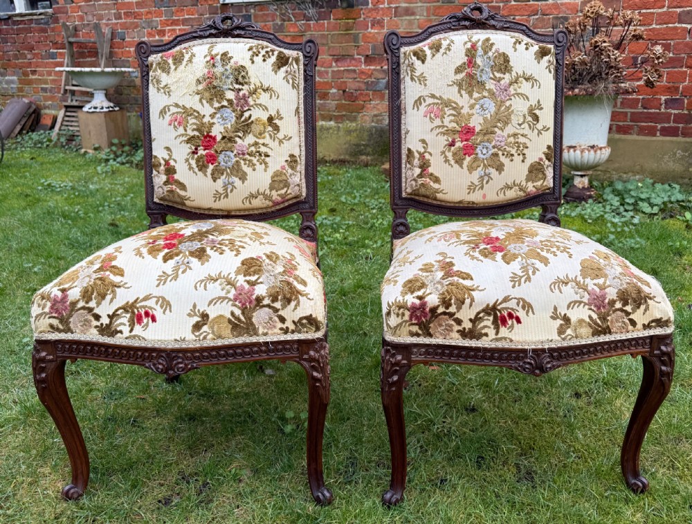A pair of carved mahogany side chairs featuring cream floral velvet upholstery, cabriole legs, and detailed cresting carvings. View II