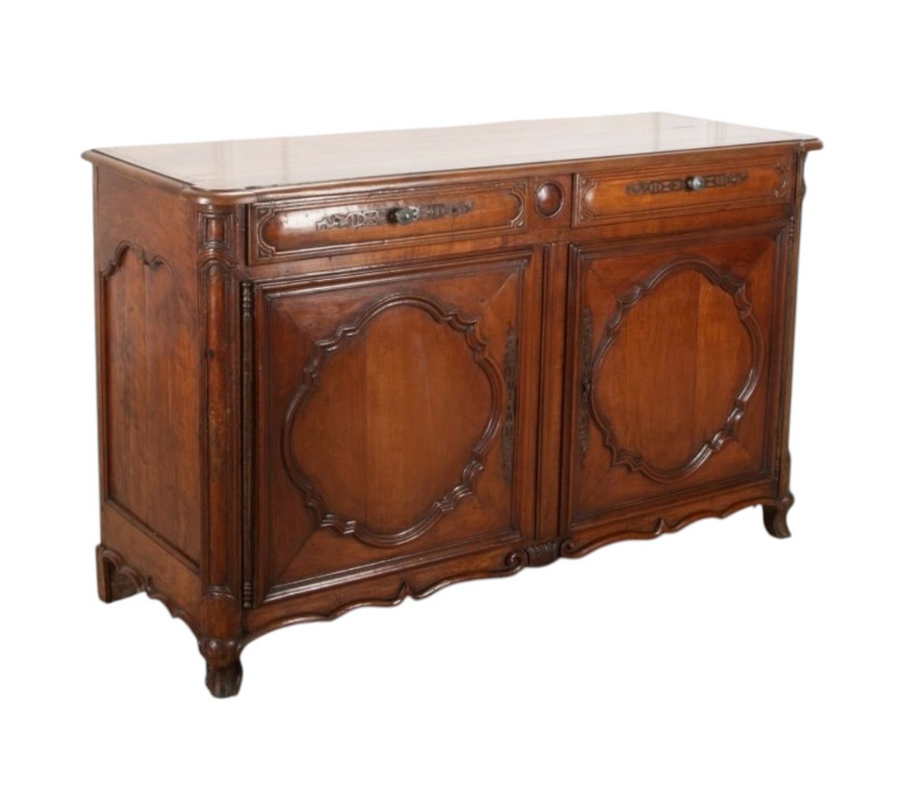 An 18th-century French provincial cherry wood buffet with two carved panel doors, two upper drawers, and short cabriole feet.