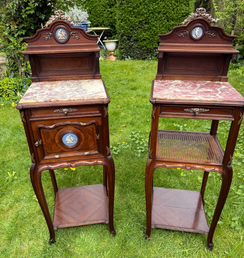 A pair of French Neoclassical wooden bedside tables featuring red marble tops, ceramic medallion inserts, Ormolu mounts, curved legs, and lower open shelves. View II