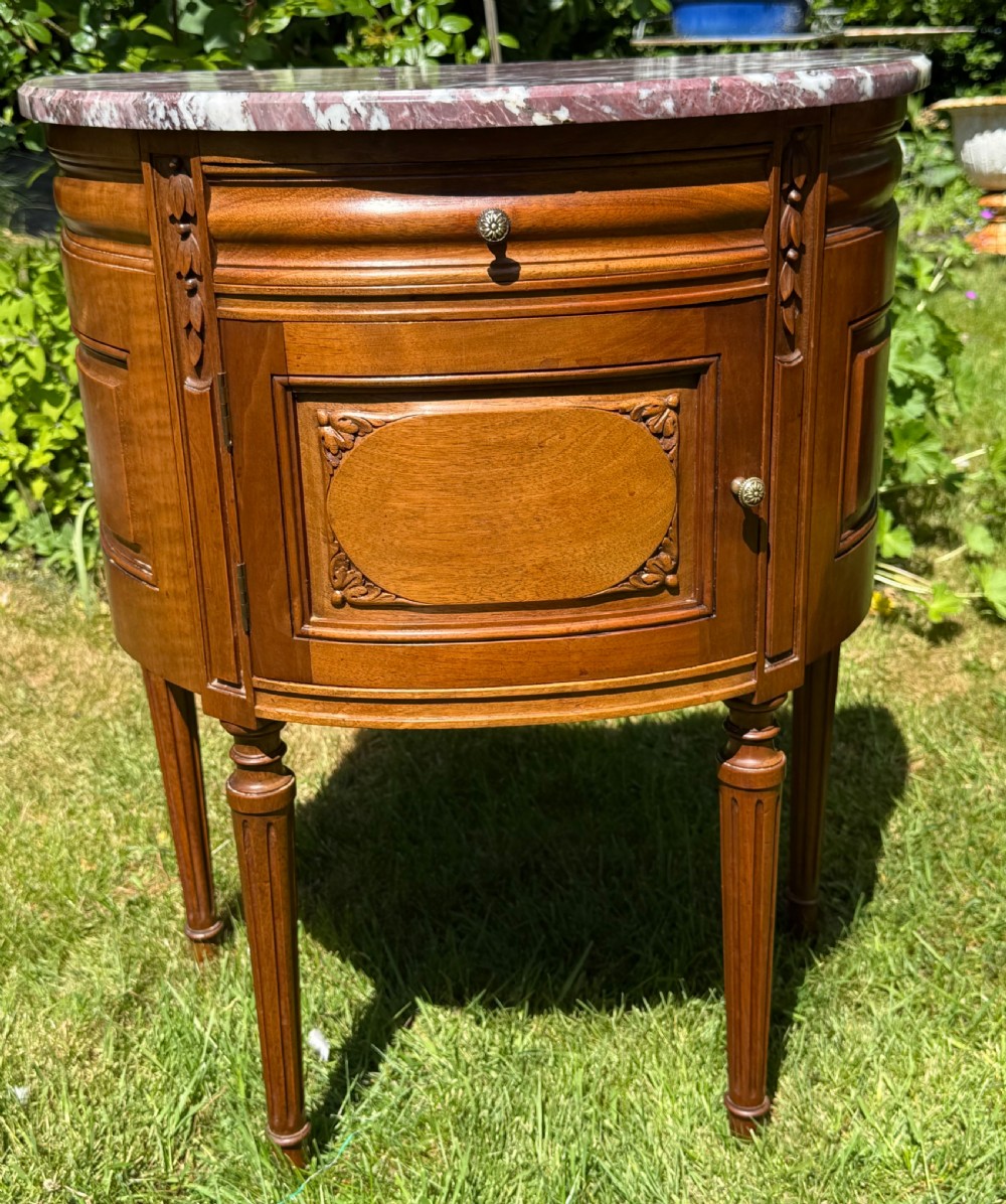 Pair of semi-circular walnut bedside cabinets with carved door panels, fluted legs, and variegated marble tops. View III
