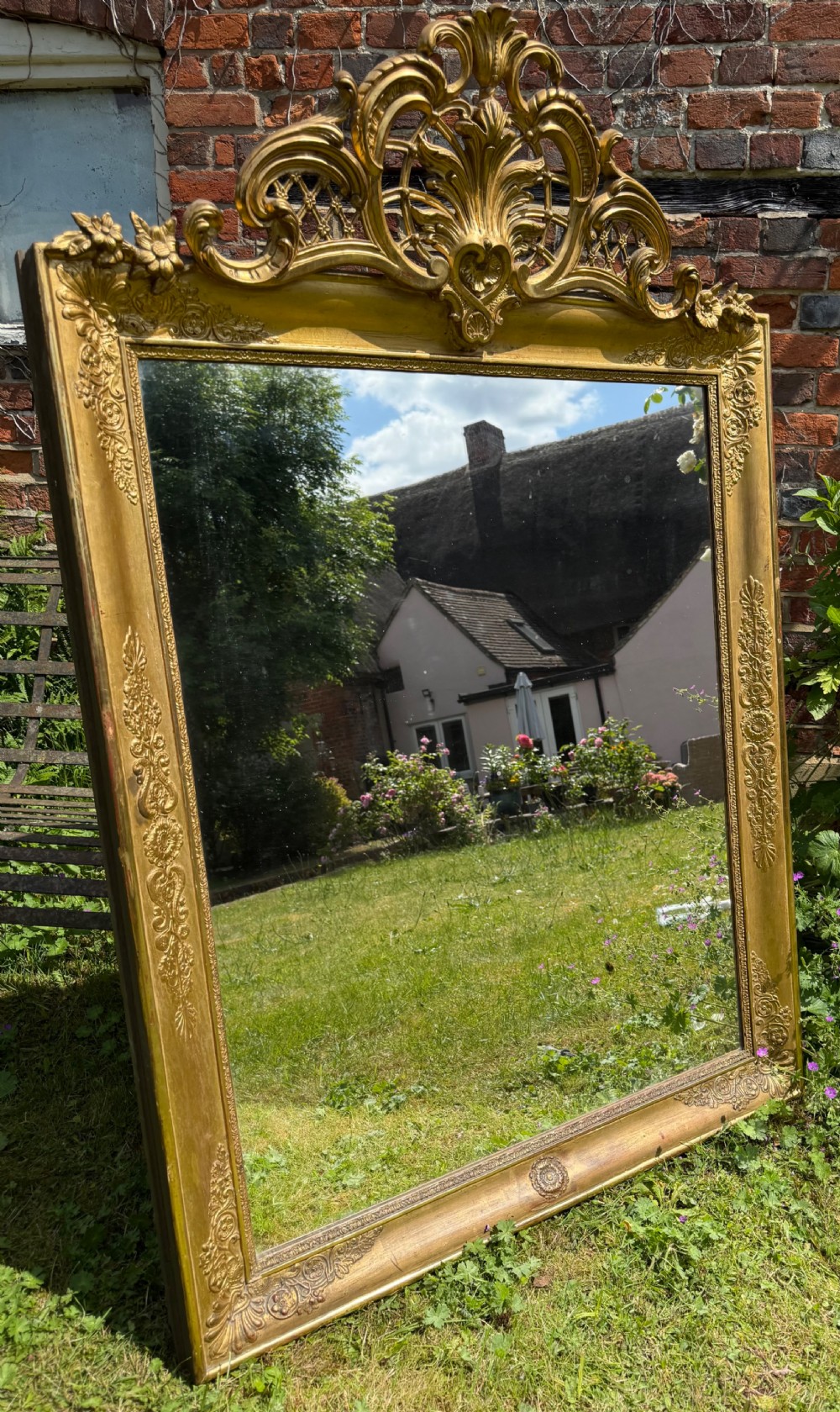 A large rectangular French Restauration giltwood mirror featuring elaborate scroll cresting and decorative corner moulding. View II