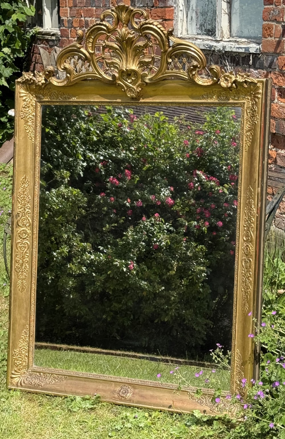 A large rectangular French Restauration giltwood mirror featuring elaborate scroll cresting and decorative corner moulding. View III