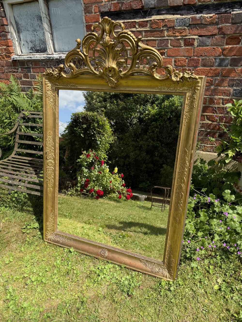 A large rectangular French Restauration giltwood mirror featuring elaborate scroll cresting and decorative corner moulding. View IV