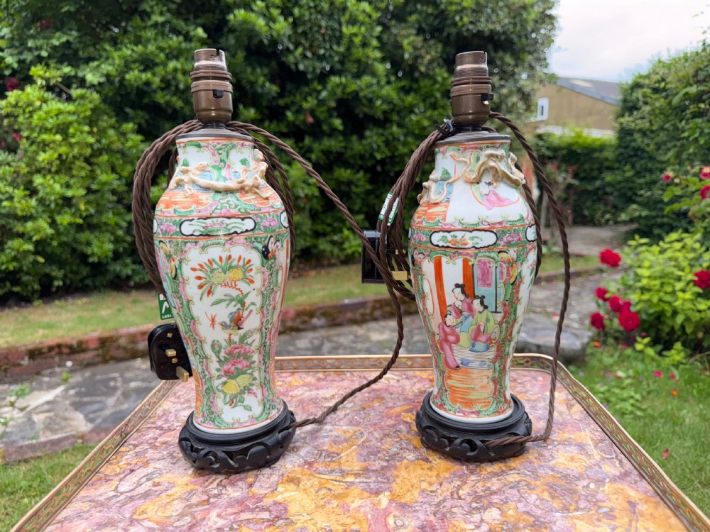 A pair of 19th-century Chinese Famille Rose porcelain vase-form table lamps decorated with colourful figures and foliage, mounted on carved dark wooden bases. View III