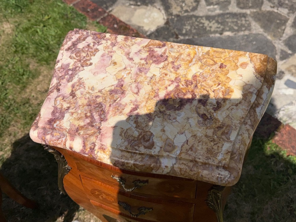 A pair of French Louis XV style marquetry bedside tables featuring marble tops, three floral inlaid drawers, gilt bronze mounts, and slender cabriole legs. View III