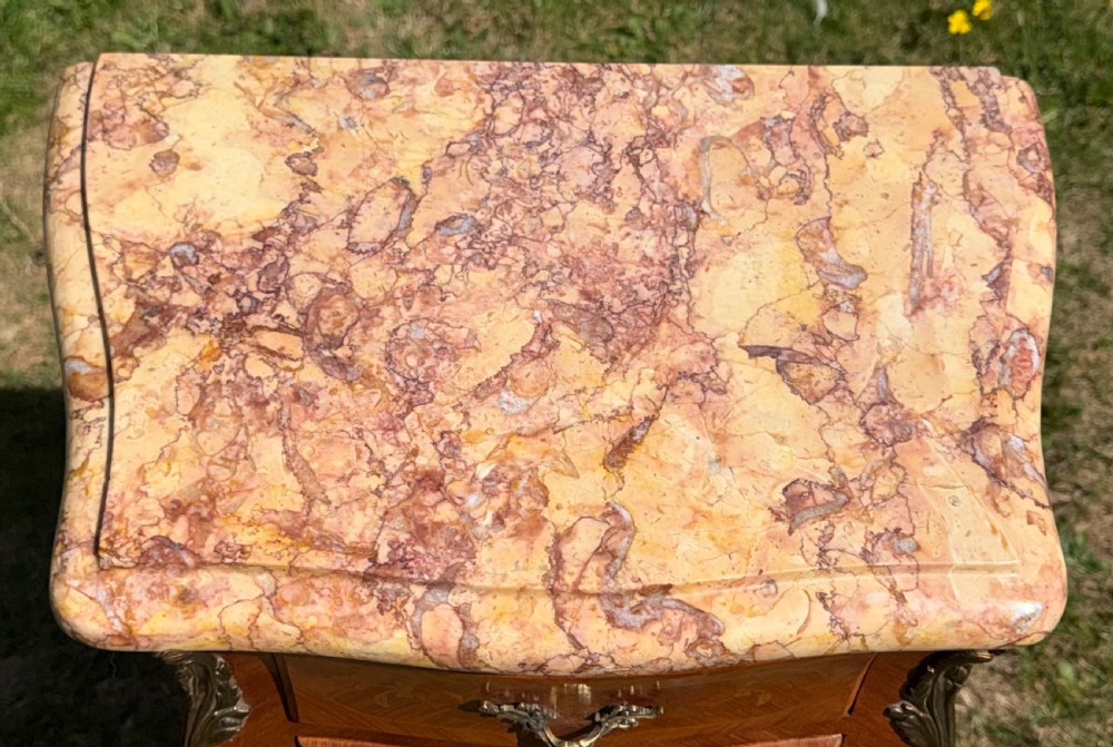 A pair of French Louis XV style marquetry bedside tables featuring marble tops, three floral inlaid drawers, gilt bronze mounts, and slender cabriole legs. View VI
