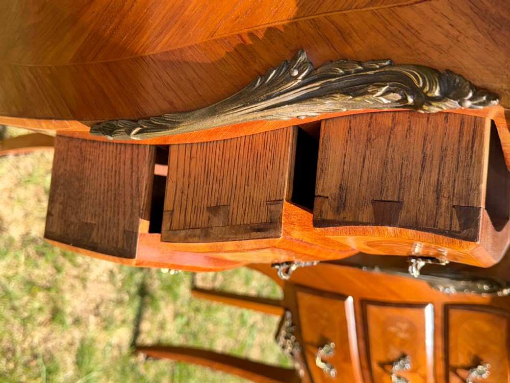 A pair of French Louis XV style marquetry bedside tables featuring marble tops, three floral inlaid drawers, gilt bronze mounts, and slender cabriole legs. View IX
