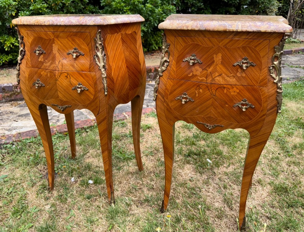 Pair of French Rococo style bedside tables featuring floral wood marquetry, curved cabriole legs, gilt metal mounts, and polished marble tops. View V