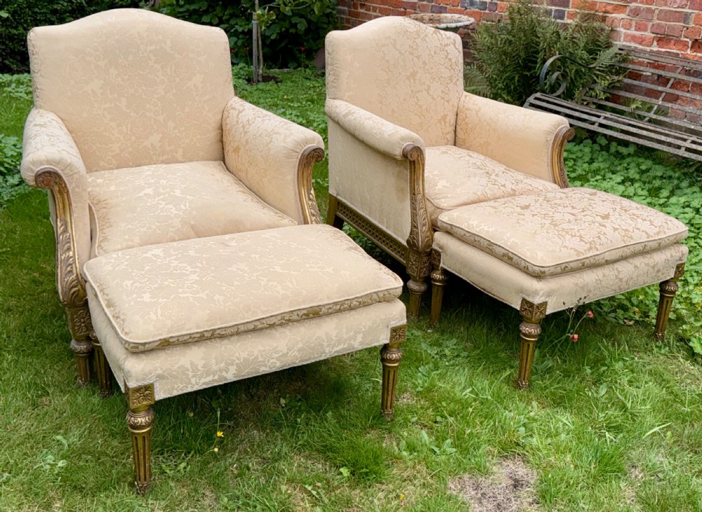 A pair of giltwood armchairs upholstered in cream damask pattern fabric with matching footstools. View VI