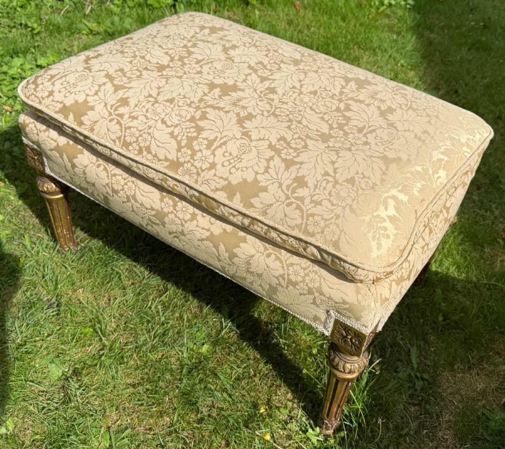 A pair of giltwood armchairs upholstered in cream damask pattern fabric with matching footstools. View VII