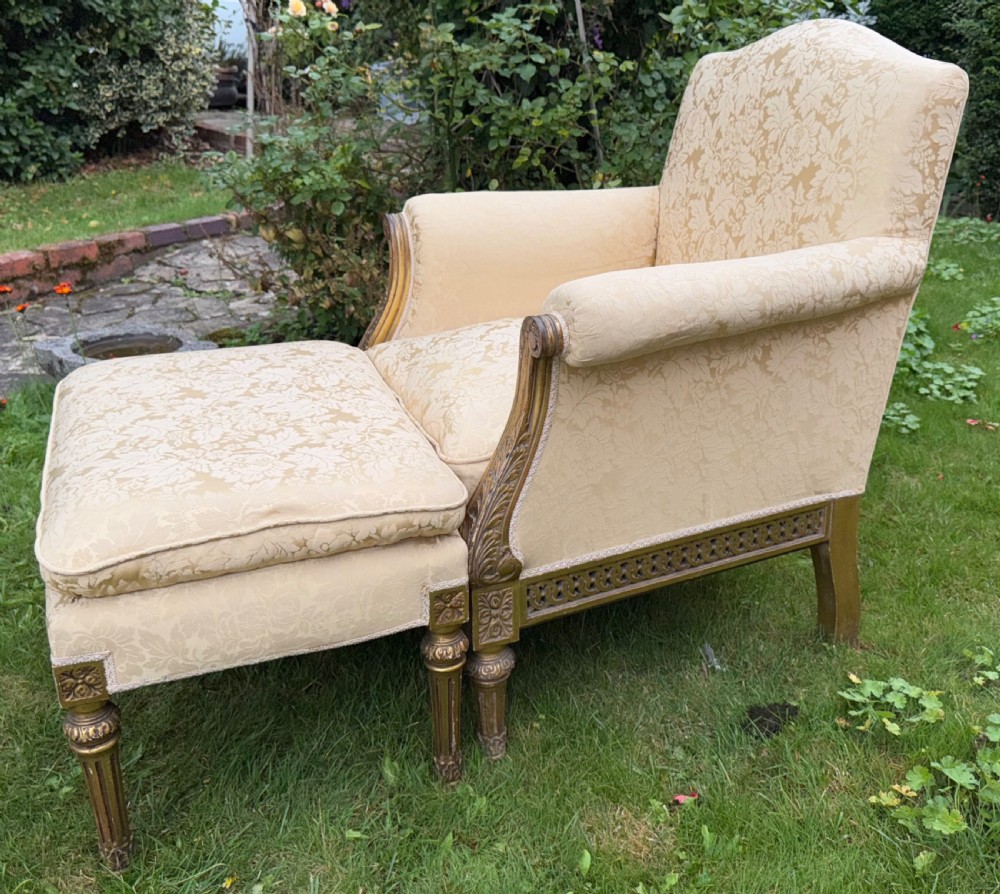 A pair of giltwood armchairs upholstered in cream damask pattern fabric with matching footstools. View VIII