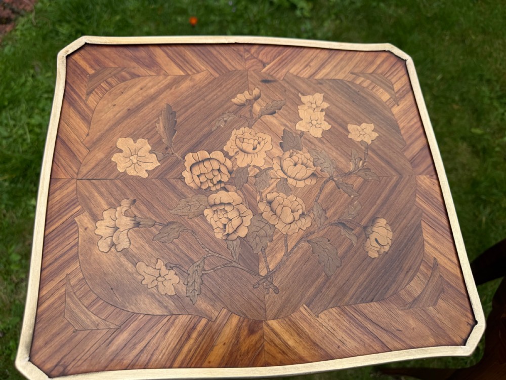 A pair of French Louis XV style marquetry bedside tables with floral wood inlays, brass rimmed tops, twin drawers, and slender cabriole legs. View III
