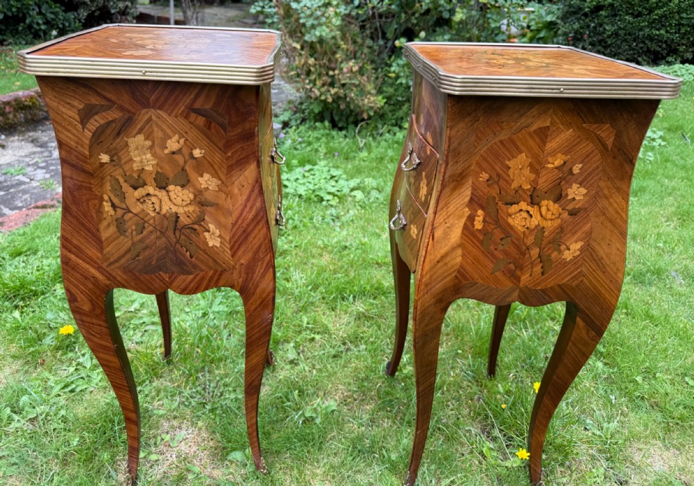 A pair of French Louis XV style marquetry bedside tables with floral wood inlays, brass rimmed tops, twin drawers, and slender cabriole legs. View VII