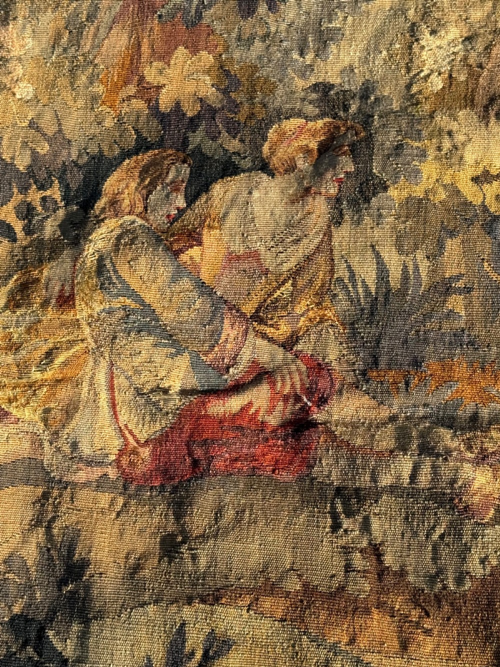 A 19th-century woven wall tapestry depicting a pastoral landscape scene with figures in romantic attire within a detailed floral border. View VI
