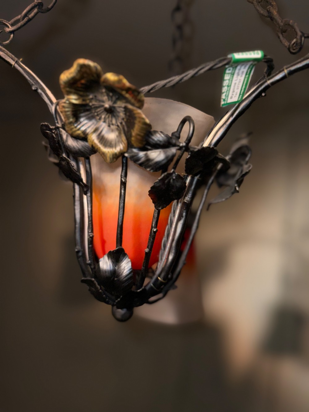 A pair of French Art Nouveau wrought iron chandeliers with floral frameworks supporting mottled orange and cream glass shades. View IV
