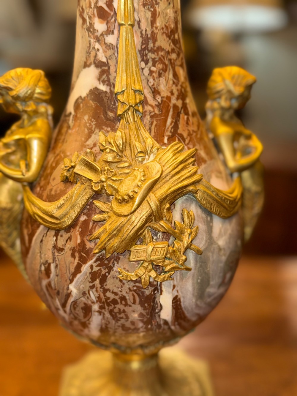 A pair of large table lamps featuring brown veined marble urn-shaped bases adorned with ornate gilt bronze mounts and fitted with pleated fabric shades. View II