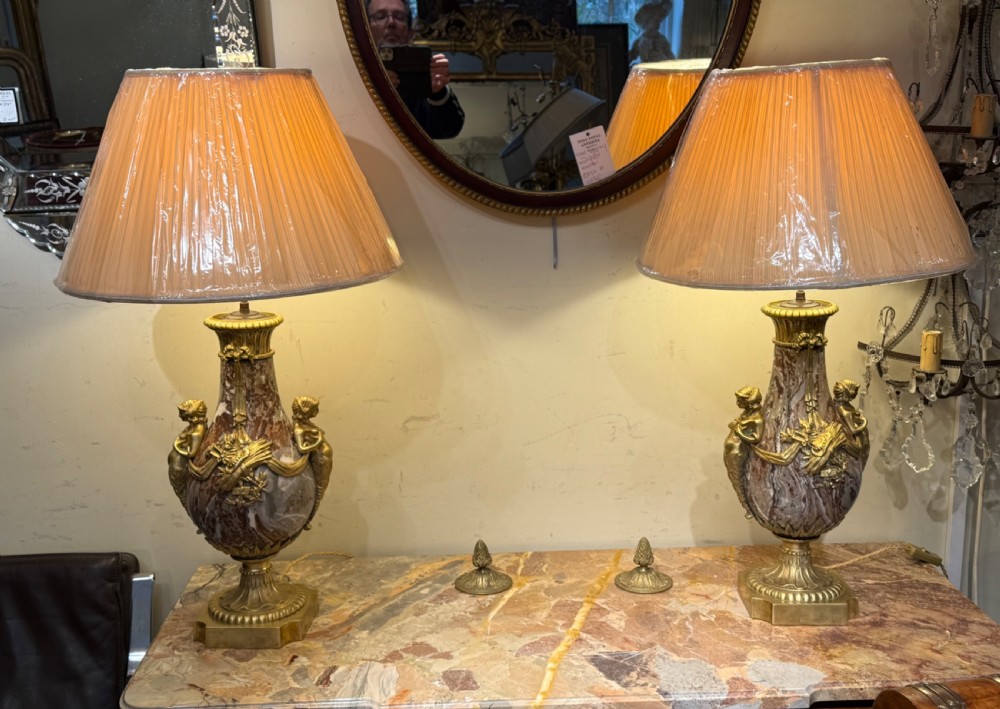 A pair of large table lamps featuring brown veined marble urn-shaped bases adorned with ornate gilt bronze mounts and fitted with pleated fabric shades. View V