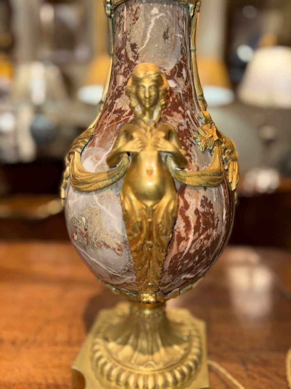A pair of large table lamps featuring brown veined marble urn-shaped bases adorned with ornate gilt bronze mounts and fitted with pleated fabric shades. View VI