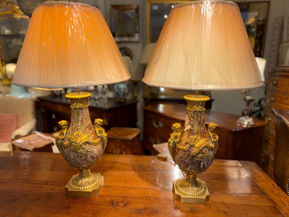 A pair of large table lamps featuring brown veined marble urn-shaped bases adorned with ornate gilt bronze mounts and fitted with pleated fabric shades. View VIII