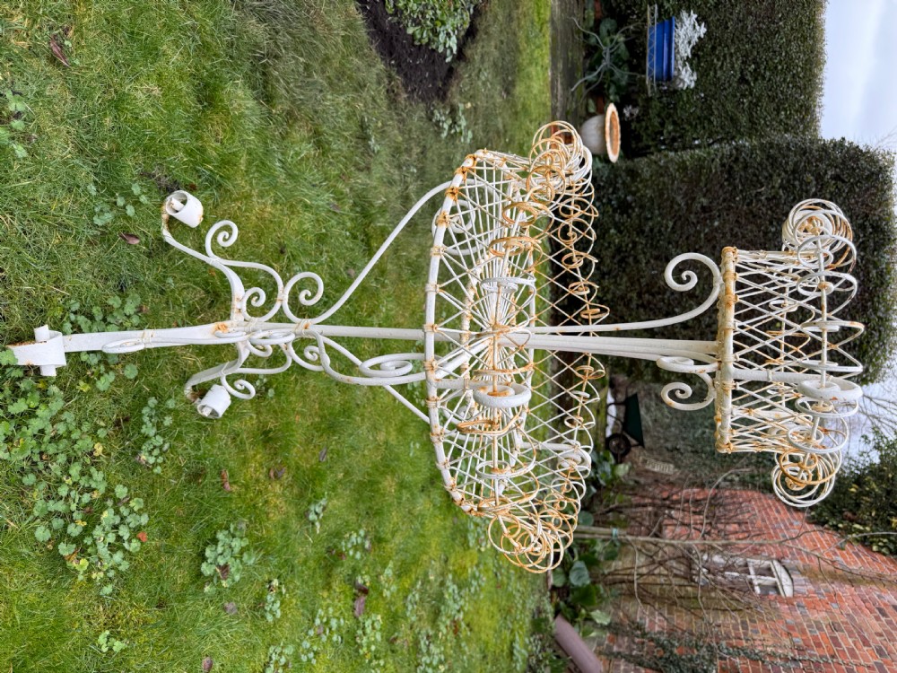 A 19th-century two-tiered white painted iron wirework jardiniere featuring intricate lattice patterning and scrollwork legs. View II