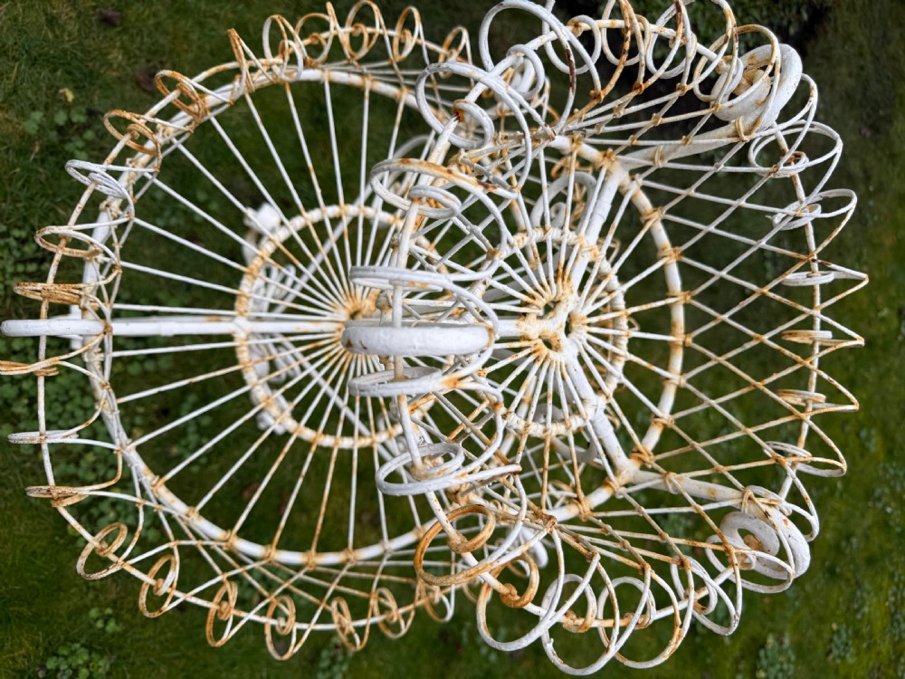 A 19th-century two-tiered white painted iron wirework jardiniere featuring intricate lattice patterning and scrollwork legs. View III