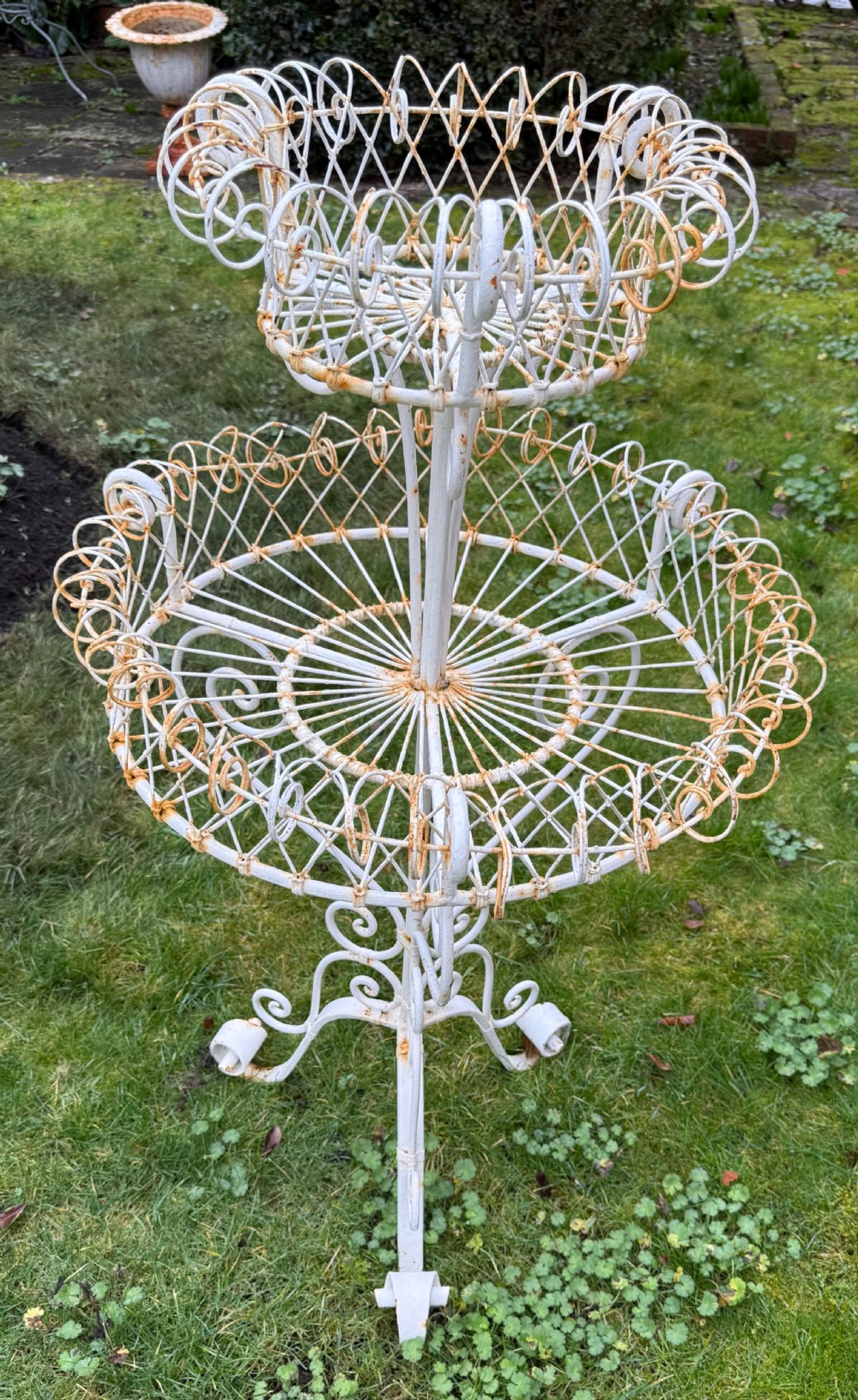A 19th-century two-tiered white painted iron wirework jardiniere featuring intricate lattice patterning and scrollwork legs. View V