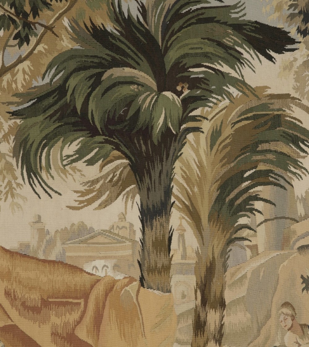 A large rectangular 19th-century French Aubusson style woven tapestry depicting figures under palm trees within a decorative foliage border. View IV