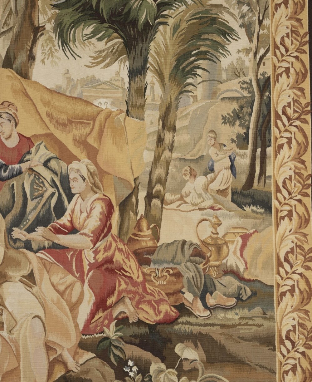 A large rectangular 19th-century French Aubusson style woven tapestry depicting figures under palm trees within a decorative foliage border. View V