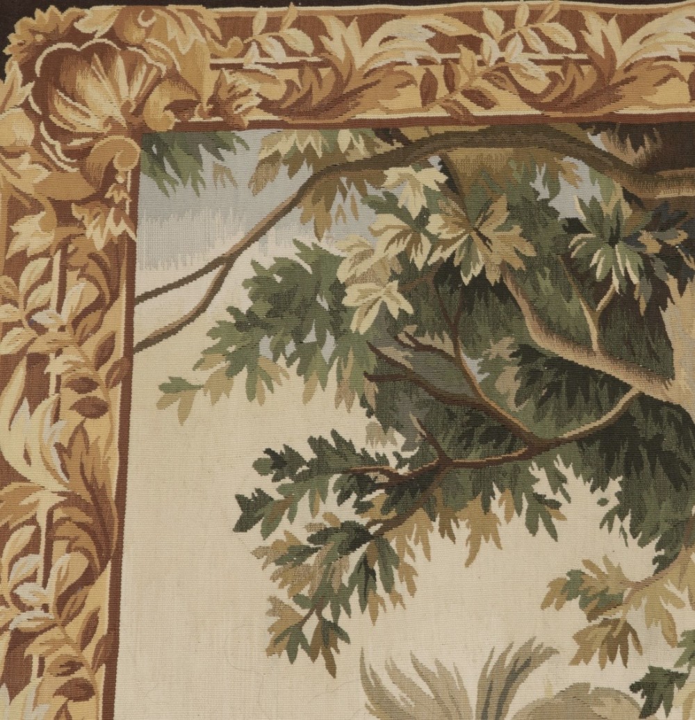 A large rectangular 19th-century French Aubusson style woven tapestry depicting figures under palm trees within a decorative foliage border. View IX