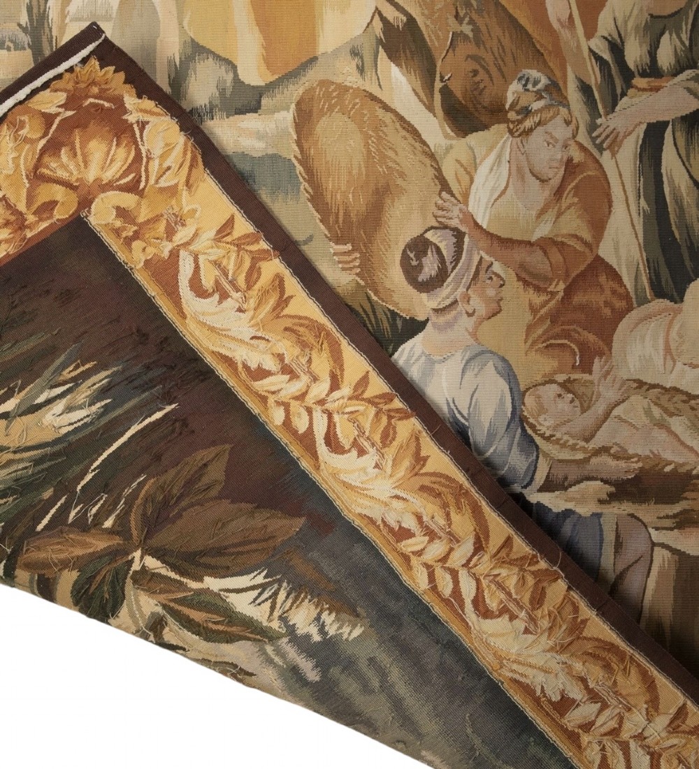 A large rectangular 19th-century French Aubusson style woven tapestry depicting figures under palm trees within a decorative foliage border. View XI
