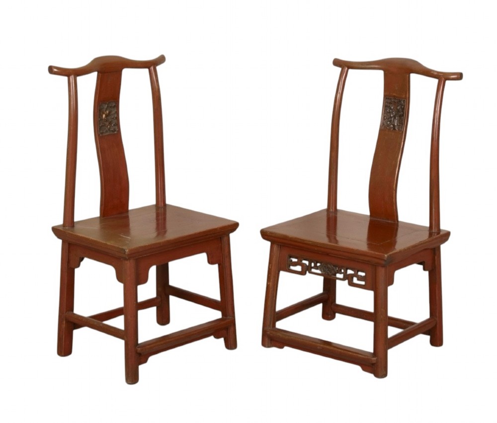 A matched pair of 19th-century Chinese side chairs featuring curved yoke top rails, carved central back splats, square timber seats, and a reddish-brown lacquered finish.