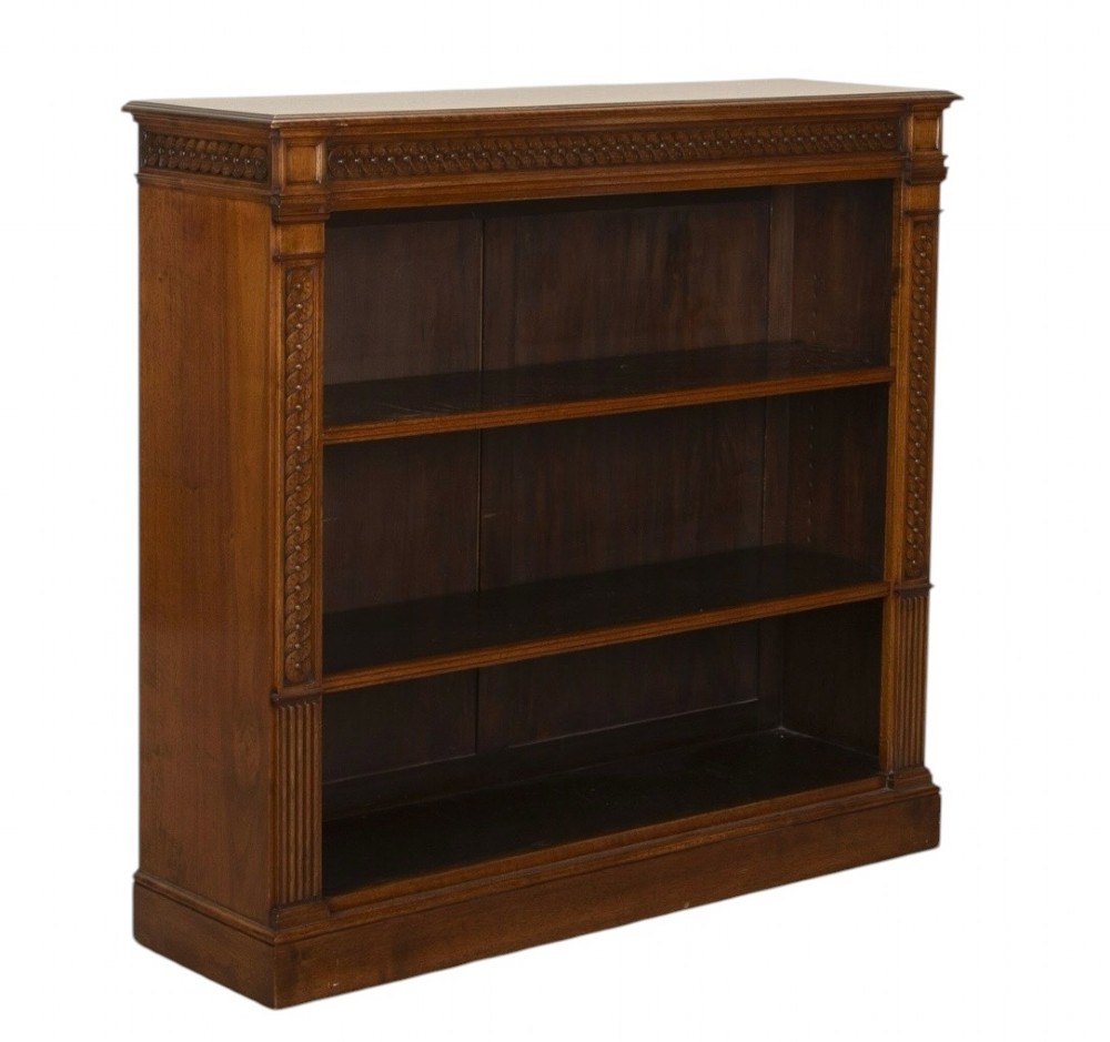 A late nineteenth-century Victorian walnut open bookcase featuring three horizontal shelves, carved frieze detail, and fluted side pilasters on a solid plinth base. View II