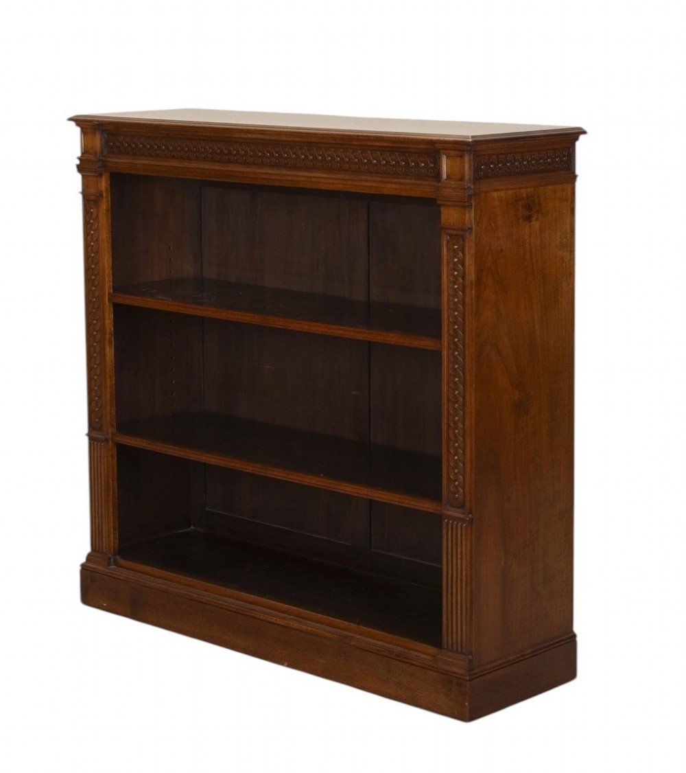 A late nineteenth-century Victorian walnut open bookcase featuring three horizontal shelves, carved frieze detail, and fluted side pilasters on a solid plinth base. View III