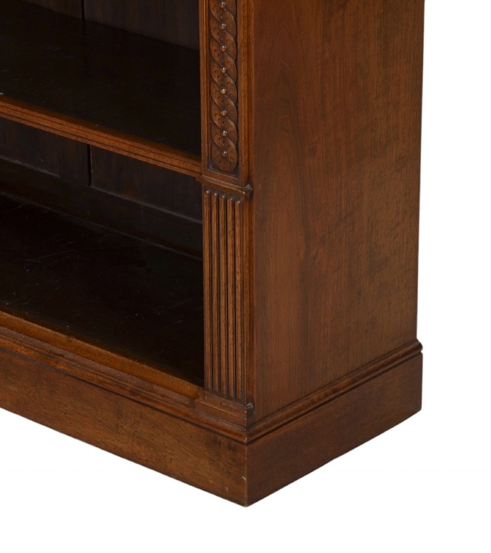 A late nineteenth-century Victorian walnut open bookcase featuring three horizontal shelves, carved frieze detail, and fluted side pilasters on a solid plinth base. View V