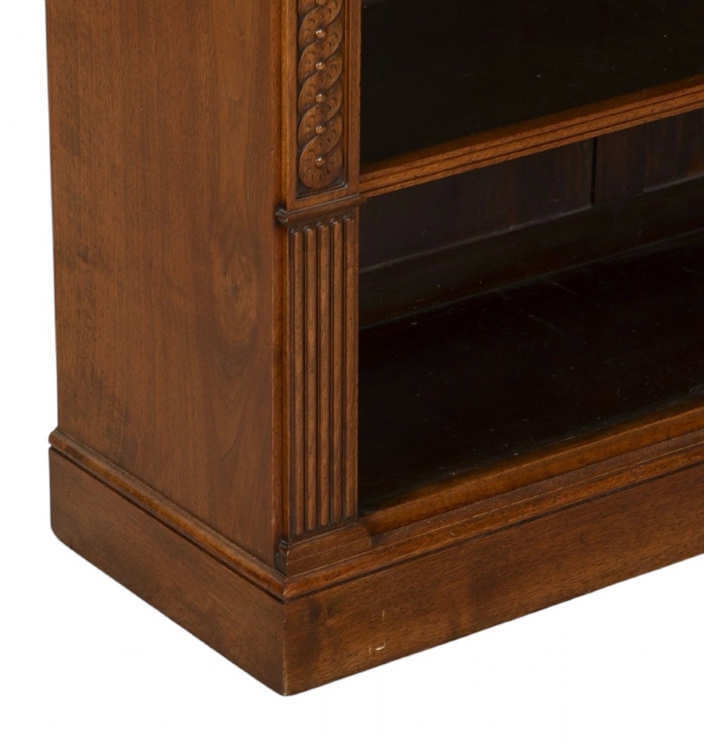A late nineteenth-century Victorian walnut open bookcase featuring three horizontal shelves, carved frieze detail, and fluted side pilasters on a solid plinth base. View VI