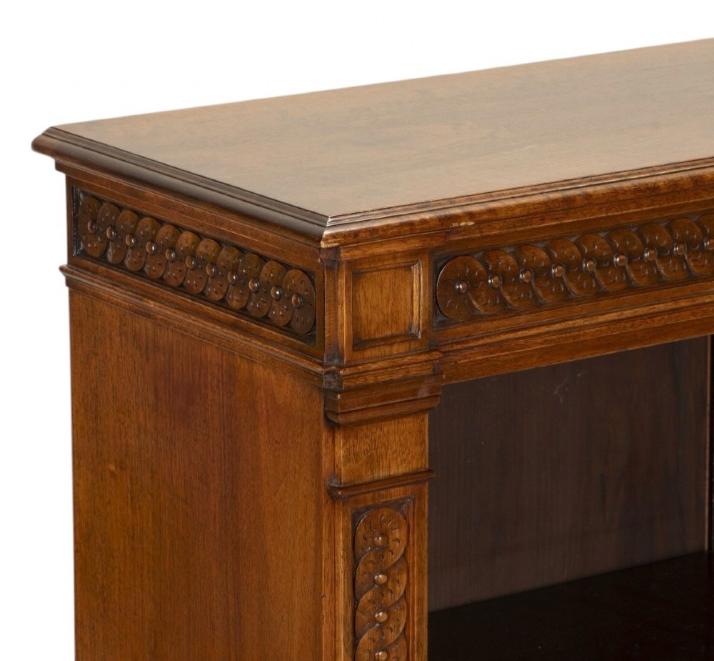A late nineteenth-century Victorian walnut open bookcase featuring three horizontal shelves, carved frieze detail, and fluted side pilasters on a solid plinth base. View VII