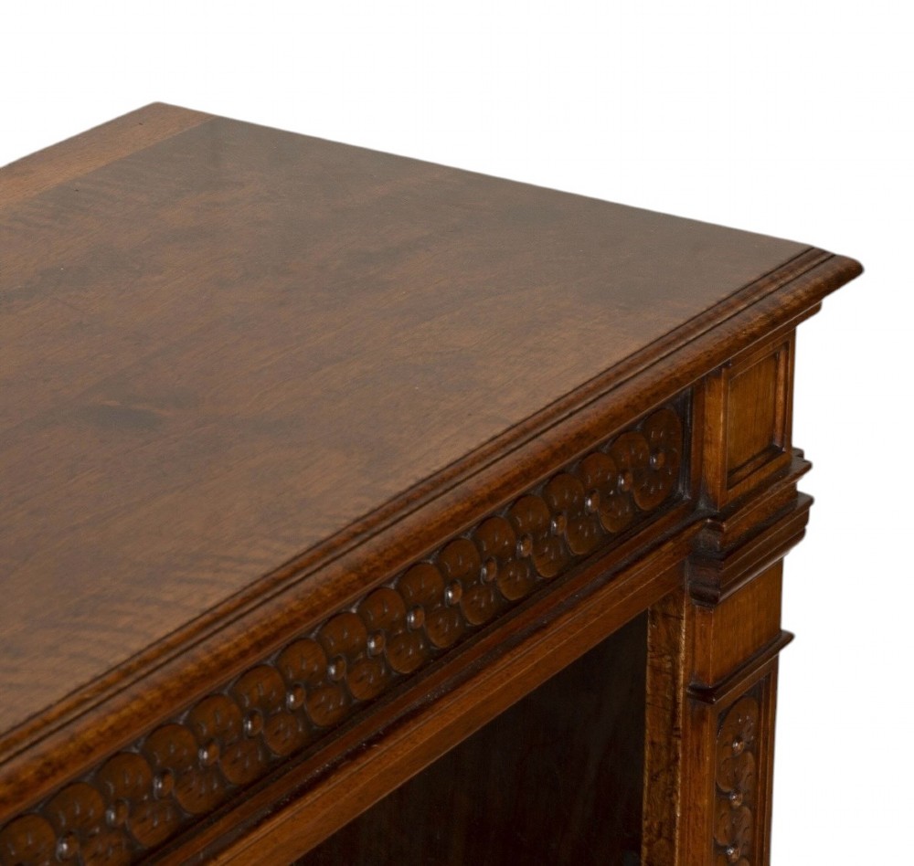A late nineteenth-century Victorian walnut open bookcase featuring three horizontal shelves, carved frieze detail, and fluted side pilasters on a solid plinth base. View VIII